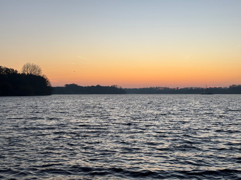 Image of Nieuwe Meer lake with sunset skies in distance 